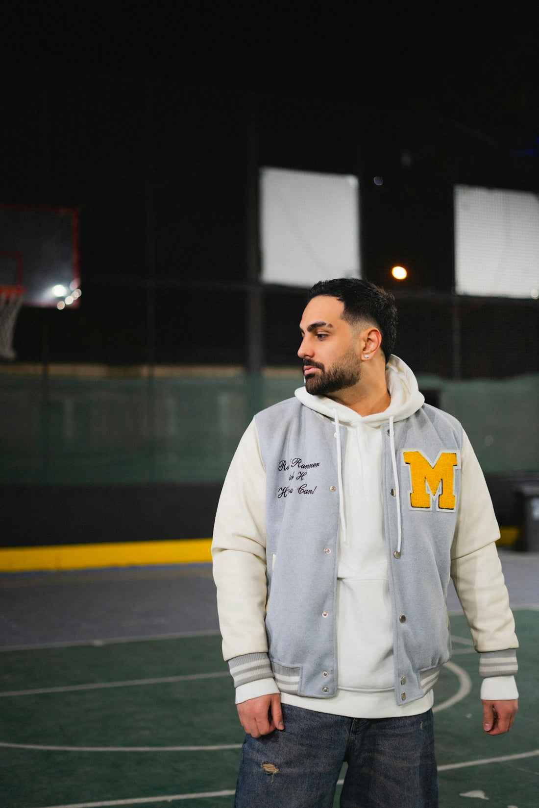 Man in varsity jacket on basketball court