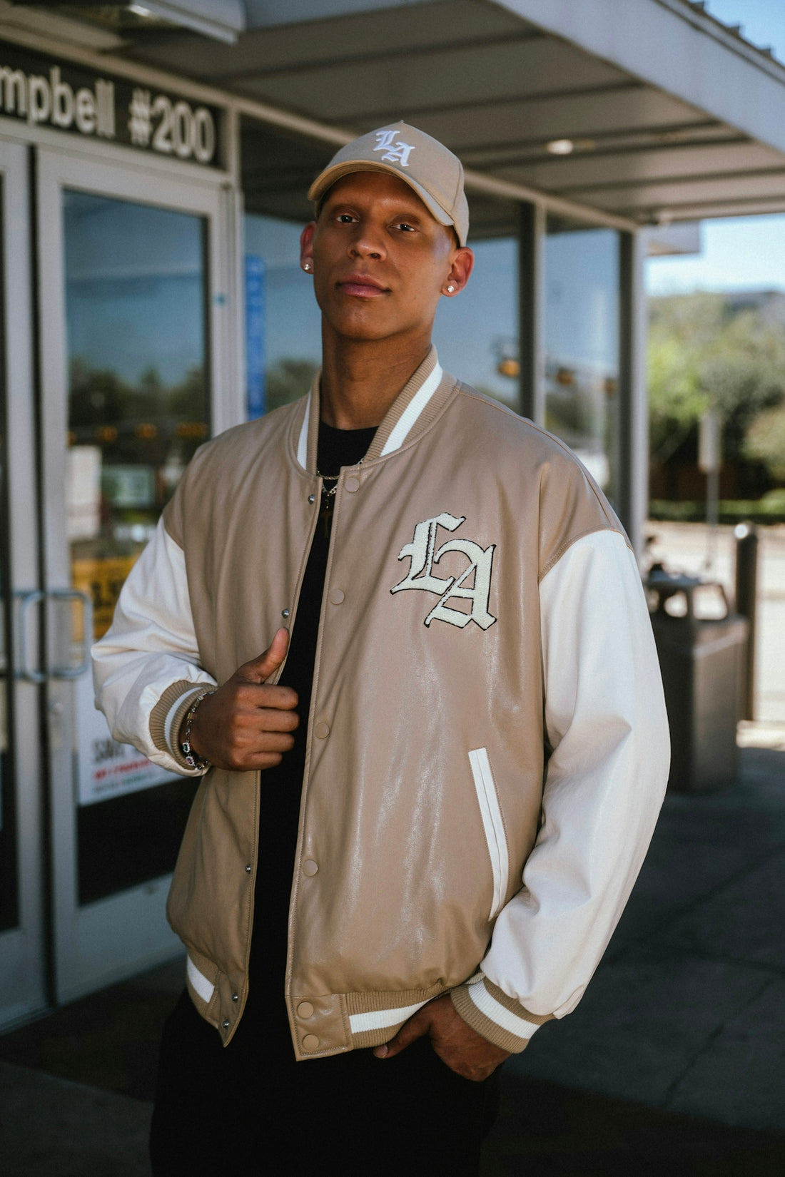 Man wearing a beige and white letterman jacket.
